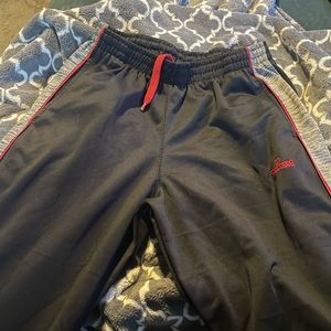 navy blue spalding track pants with gray stripes down side of legs